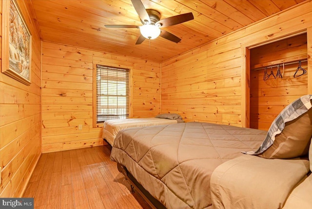 bedroom with wood walls, wood-type flooring, and wooden ceiling