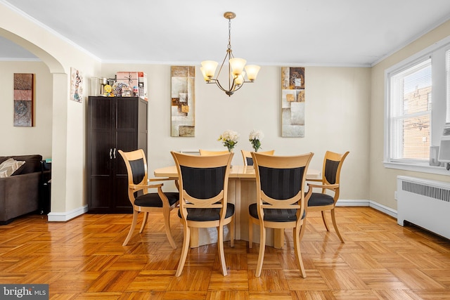 dining space featuring ornamental molding, light parquet flooring, radiator, and a notable chandelier