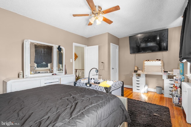 bedroom featuring ceiling fan, a textured ceiling, and light hardwood / wood-style flooring