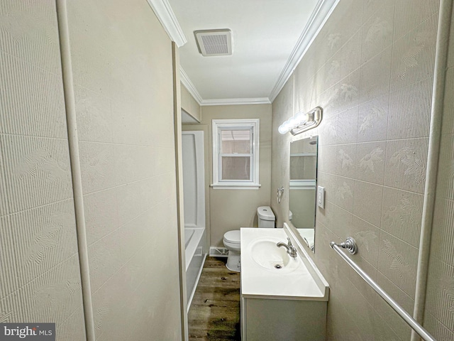 bathroom with toilet, ornamental molding, tile walls, and hardwood / wood-style flooring