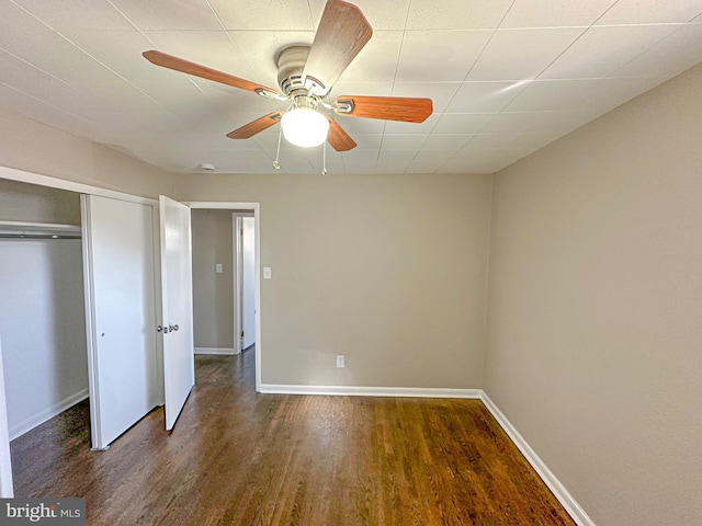 unfurnished bedroom with ceiling fan, dark hardwood / wood-style flooring, and a closet