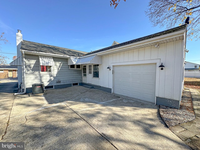 exterior space with a garage and central air condition unit