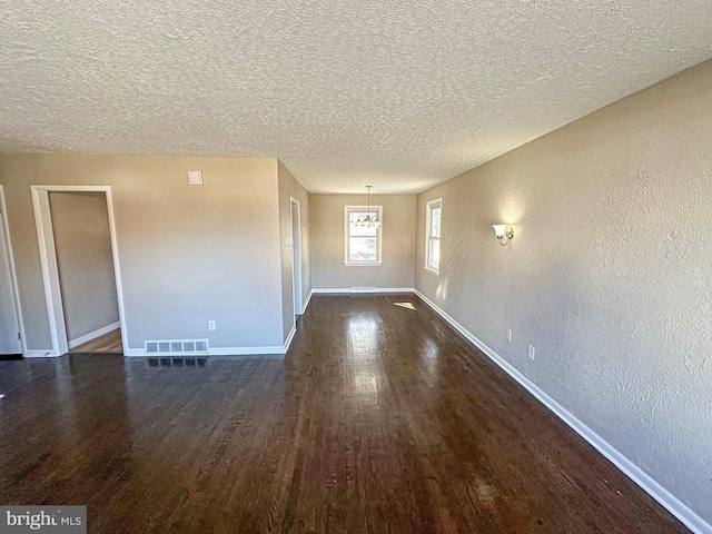 spare room with dark hardwood / wood-style flooring and a textured ceiling