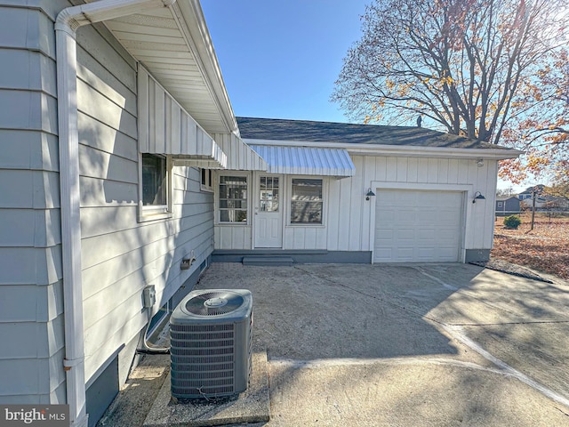 doorway to property with a garage and cooling unit