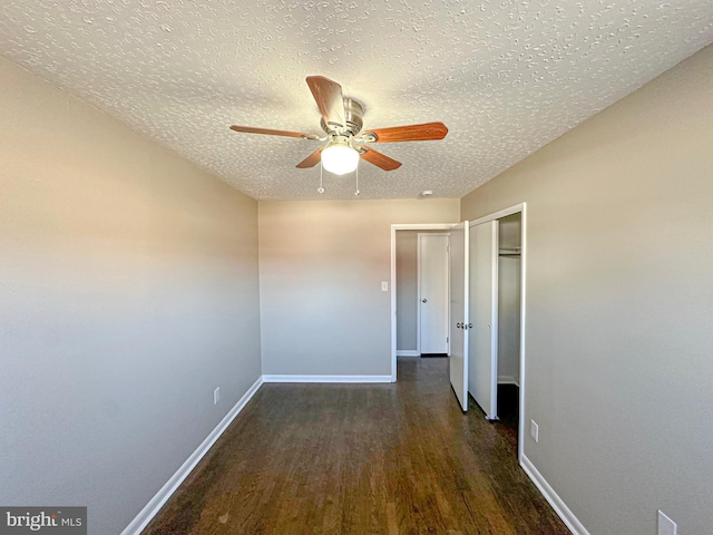 interior space featuring a textured ceiling, a closet, ceiling fan, and dark wood-type flooring