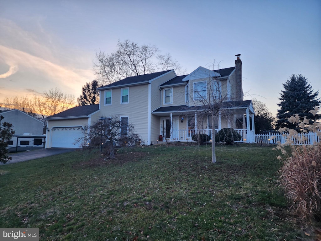 view of front of home with a porch, a garage, and a yard