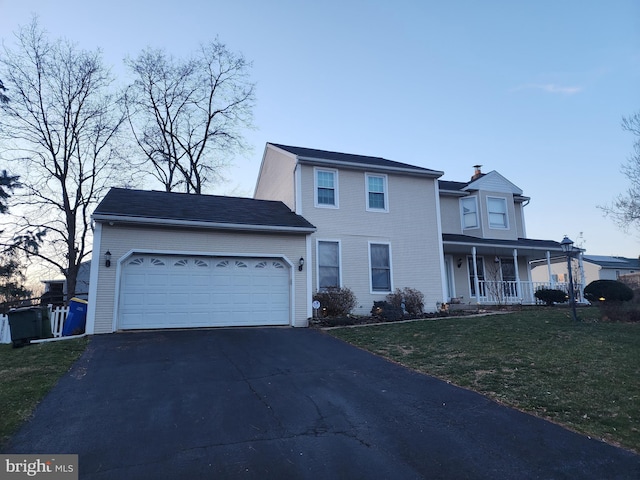 view of front of house featuring a porch, a garage, and a front lawn