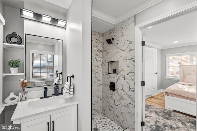 bathroom featuring tiled shower, vanity, a wealth of natural light, and ornamental molding