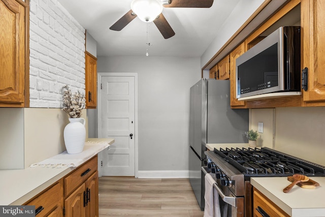 kitchen featuring ceiling fan, light hardwood / wood-style floors, and appliances with stainless steel finishes