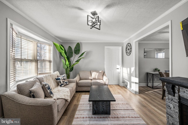 living room with crown molding, a textured ceiling, a fireplace, dark hardwood / wood-style flooring, and a chandelier