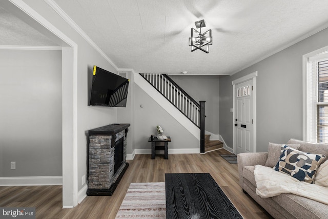 living room featuring hardwood / wood-style flooring, plenty of natural light, crown molding, and a textured ceiling