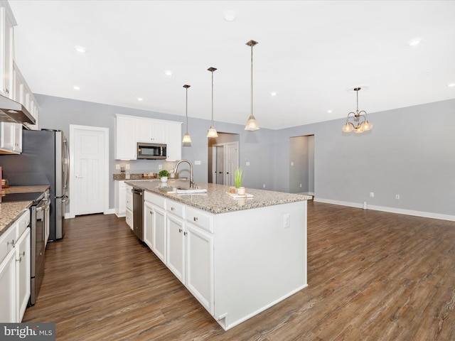 kitchen featuring appliances with stainless steel finishes, a kitchen island with sink, sink, pendant lighting, and white cabinets