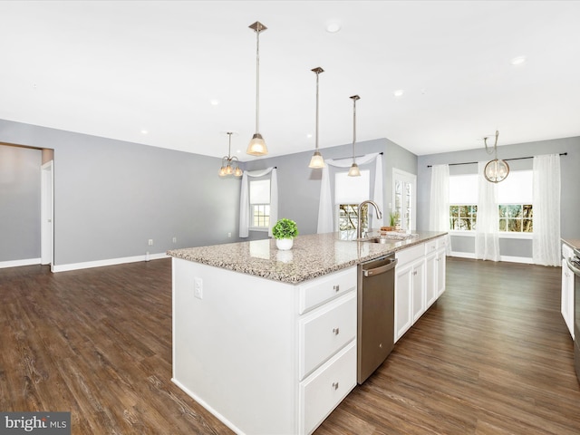 kitchen with pendant lighting, a kitchen island with sink, white cabinets, sink, and stainless steel dishwasher