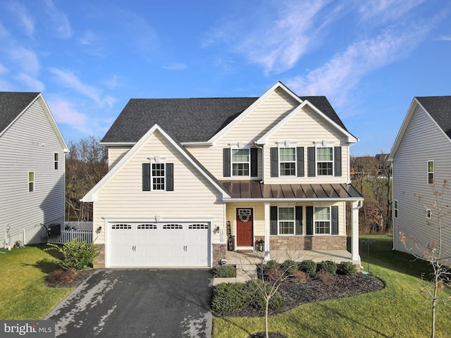 view of front of house with a front yard, a porch, and a garage