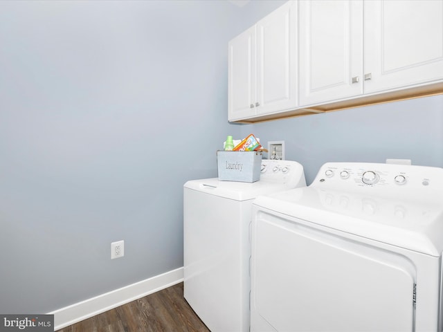 laundry room with washing machine and clothes dryer, dark hardwood / wood-style flooring, and cabinets