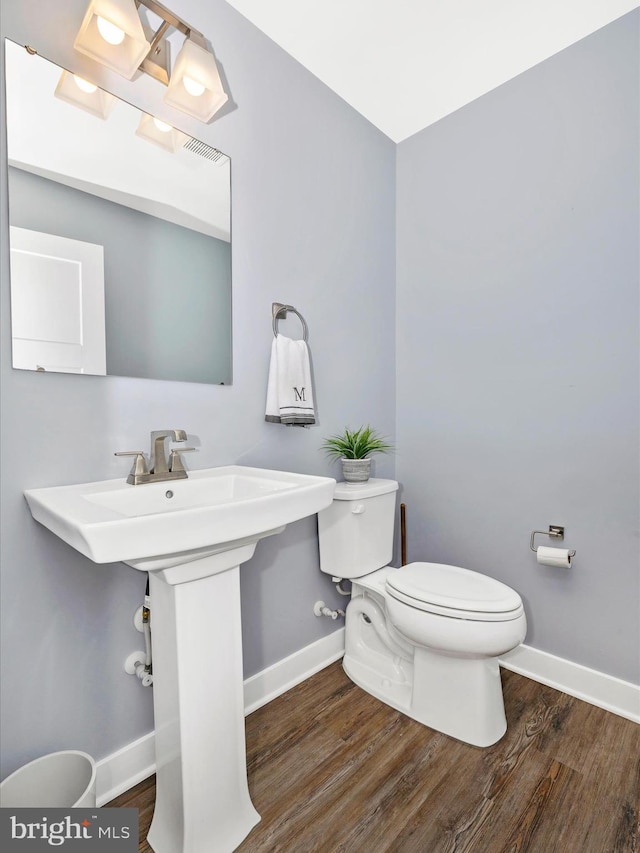 bathroom featuring wood-type flooring and toilet