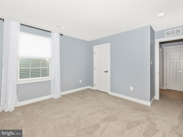 unfurnished room featuring light carpet