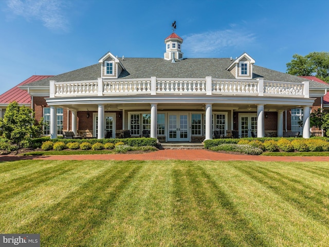 back of property with a yard and french doors