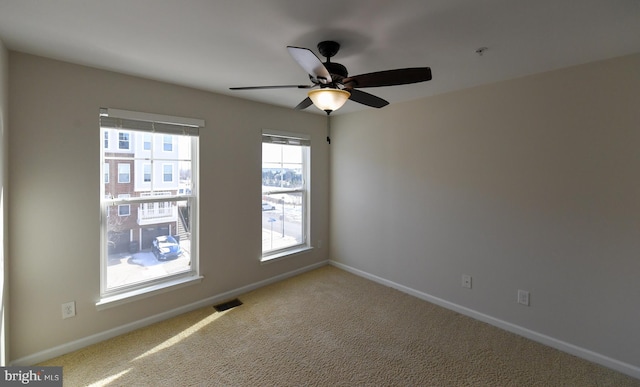 unfurnished room featuring ceiling fan and carpet