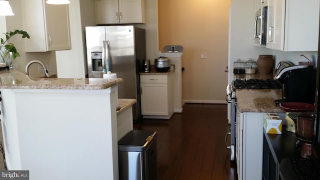 kitchen featuring sink, stainless steel fridge, dark hardwood / wood-style floors, white cabinets, and kitchen peninsula