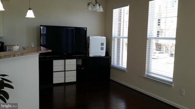 kitchen featuring dark hardwood / wood-style floors, a chandelier, hanging light fixtures, and a wealth of natural light