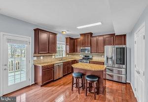 kitchen featuring a healthy amount of sunlight, appliances with stainless steel finishes, a kitchen bar, and a center island