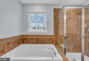 bathroom featuring separate shower and tub