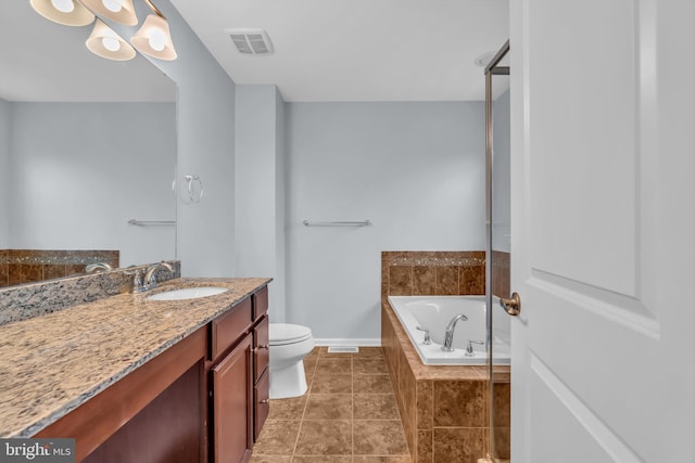 bathroom with vanity, tile patterned floors, tiled bath, and toilet