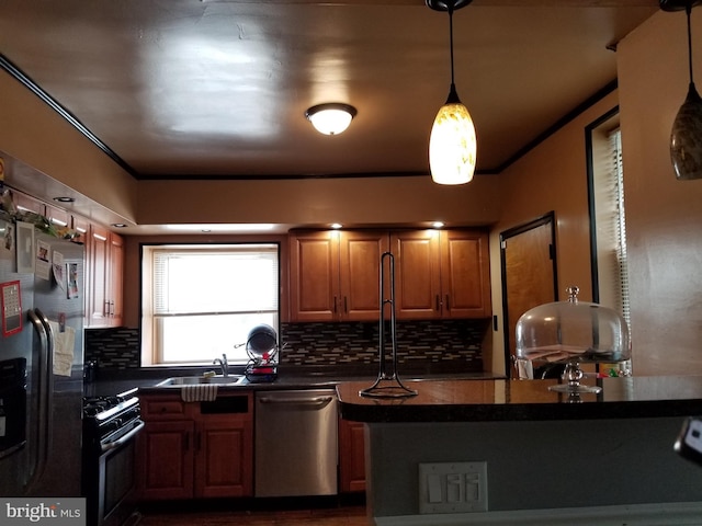 kitchen with decorative light fixtures, sink, stainless steel appliances, and tasteful backsplash