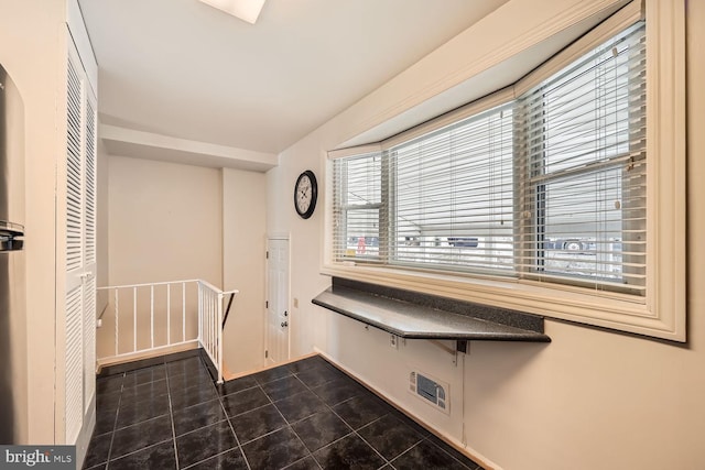 clothes washing area with dark tile patterned floors