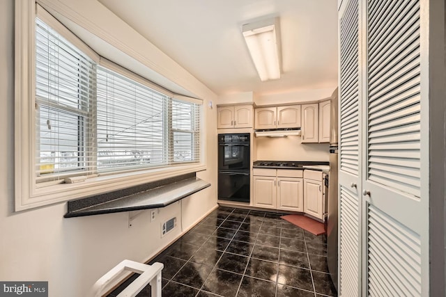 kitchen featuring gas cooktop, black double oven, and dark tile patterned flooring