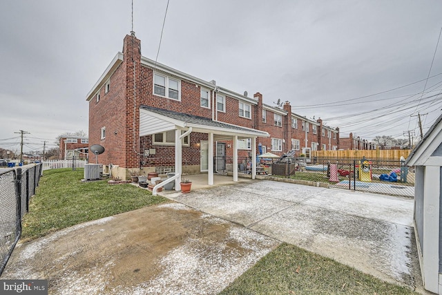 rear view of house with a lawn and a patio area