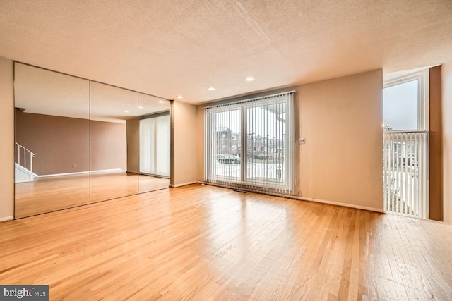 spare room with hardwood / wood-style floors and a textured ceiling