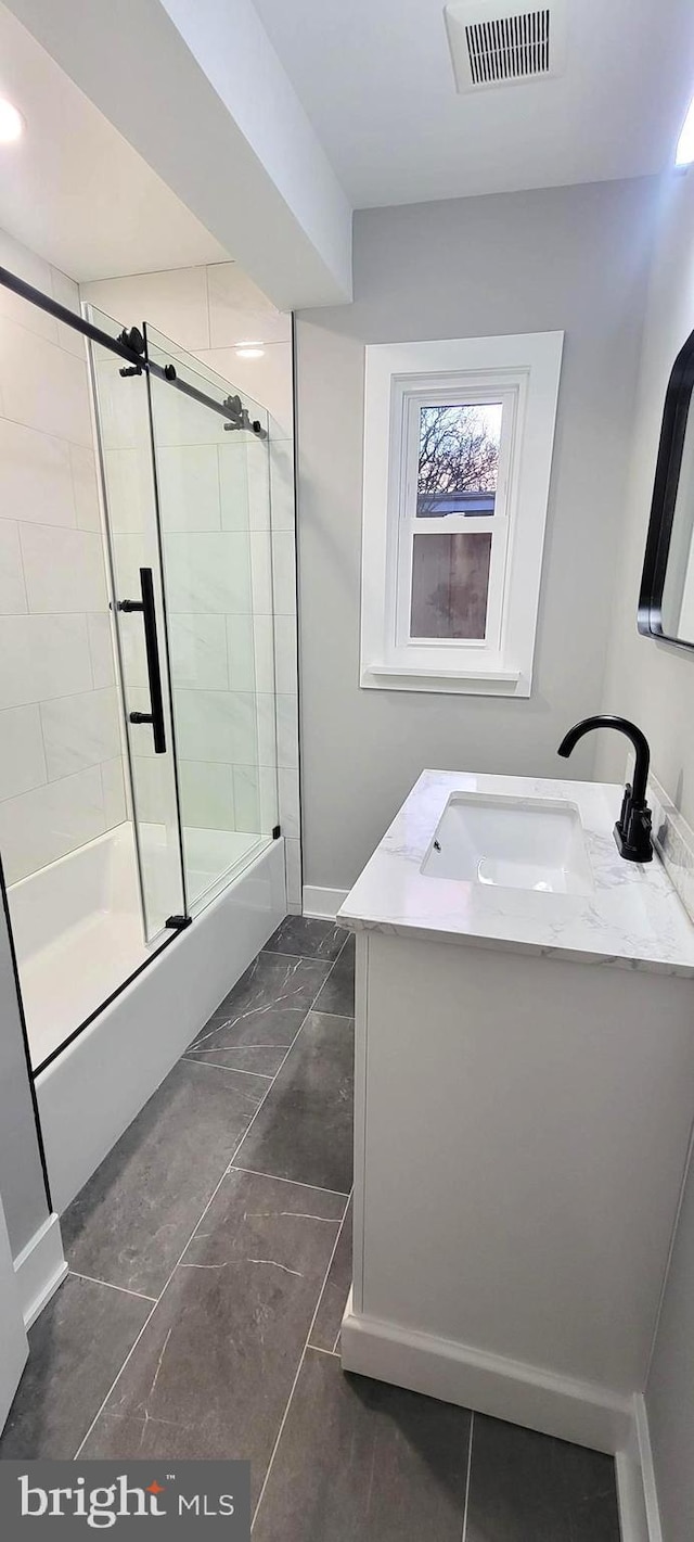 bathroom with vanity and combined bath / shower with glass door