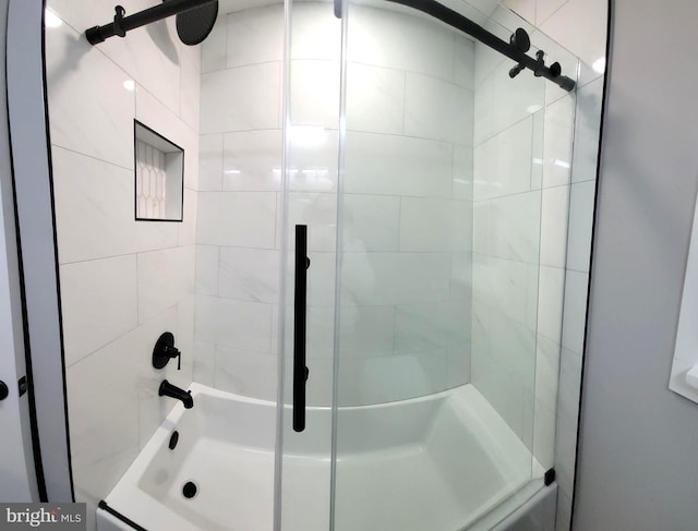 bathroom with shower / bath combination with glass door