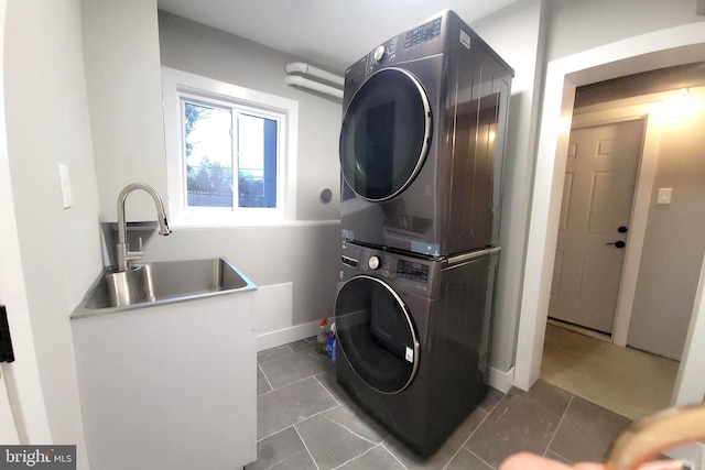 clothes washing area featuring stacked washer / drying machine and sink