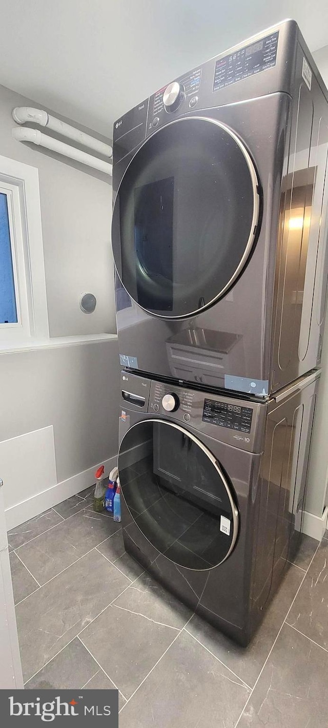 clothes washing area featuring stacked washer / dryer