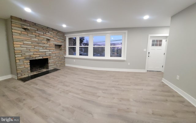 unfurnished living room with light wood-type flooring and a fireplace