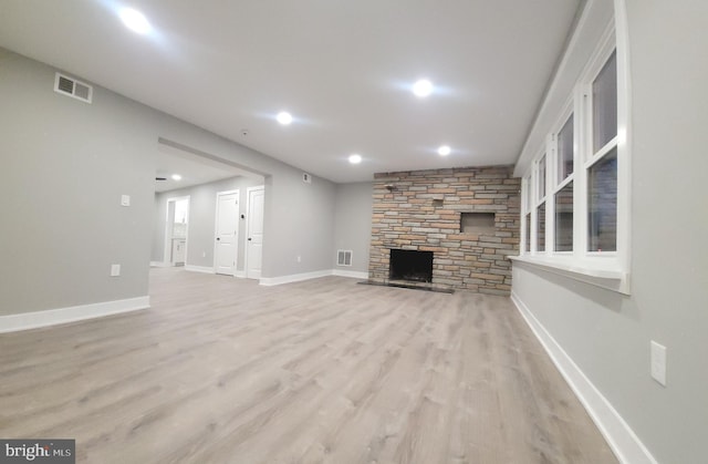 unfurnished living room with a fireplace and light wood-type flooring