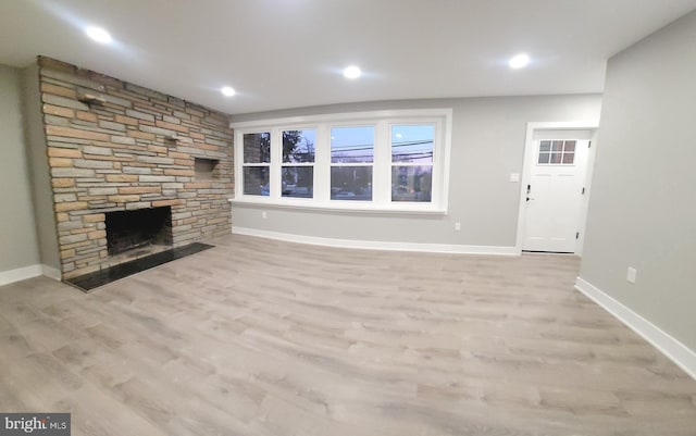 unfurnished living room with light wood-type flooring and a fireplace