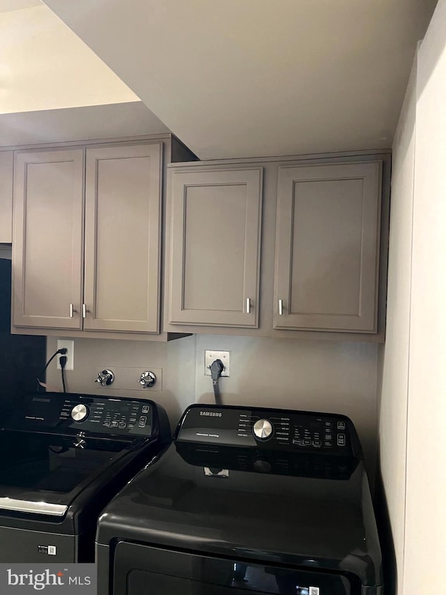 laundry area with washer and clothes dryer and cabinets