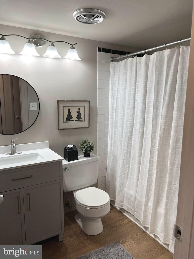 bathroom featuring a shower with shower curtain, vanity, hardwood / wood-style flooring, and toilet