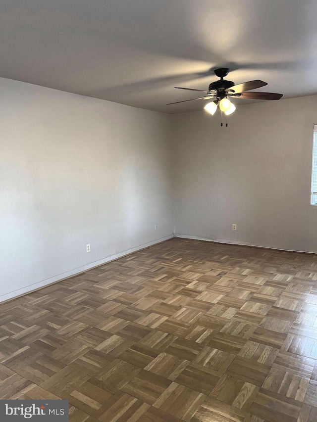 unfurnished room featuring ceiling fan and dark parquet floors