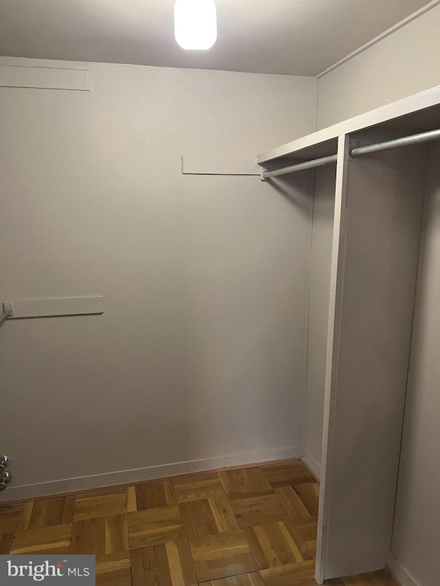 walk in closet featuring dark parquet floors