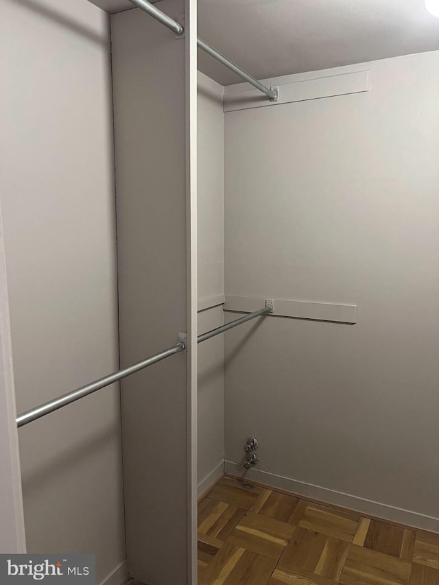 spacious closet featuring dark parquet floors