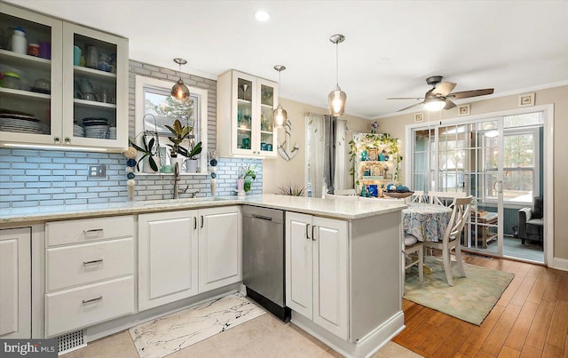 kitchen featuring dishwasher, light hardwood / wood-style flooring, plenty of natural light, and hanging light fixtures