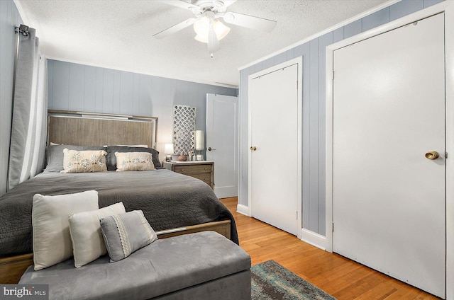 bedroom with ceiling fan, light hardwood / wood-style flooring, a textured ceiling, and ornamental molding