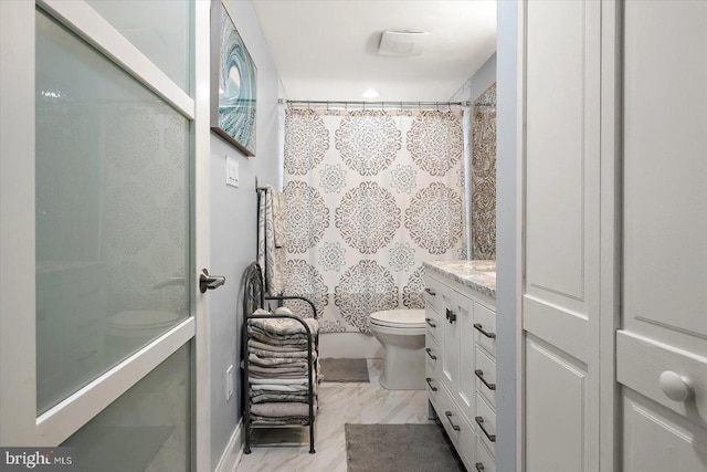 bathroom with a shower with curtain, vanity, and toilet