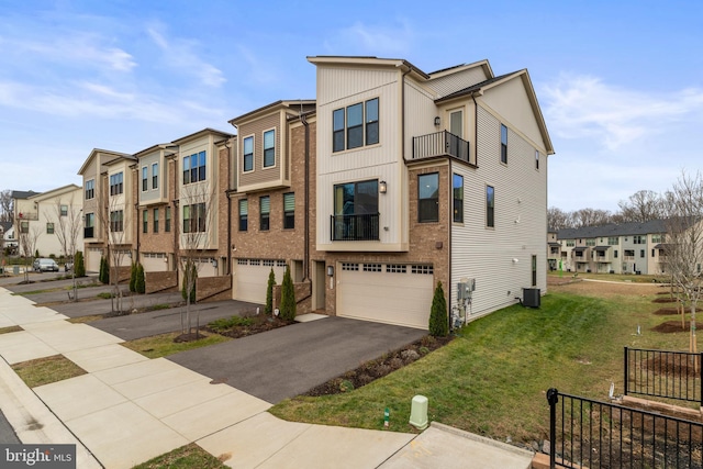 view of front of property featuring central air condition unit, a front yard, and a garage