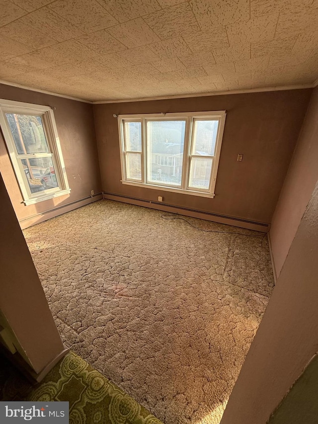 spare room with carpet floors and a baseboard heating unit